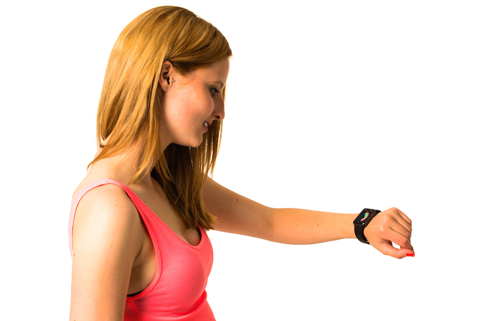 Woman checking her Apple Watch while jogging