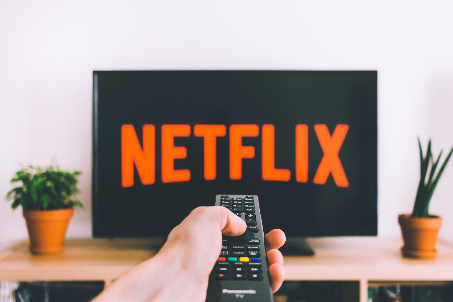 Il telecomando è puntato verso una TV con il logo Netflix
