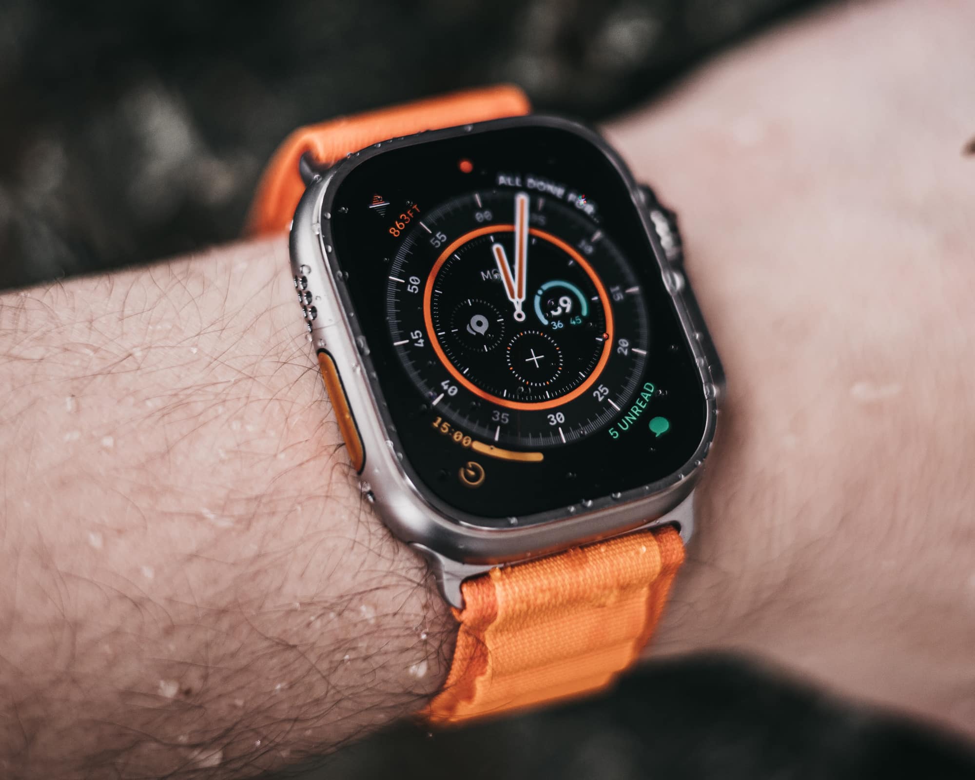 Apple Watch Ultra mit orangenem Armband am Handgelenk