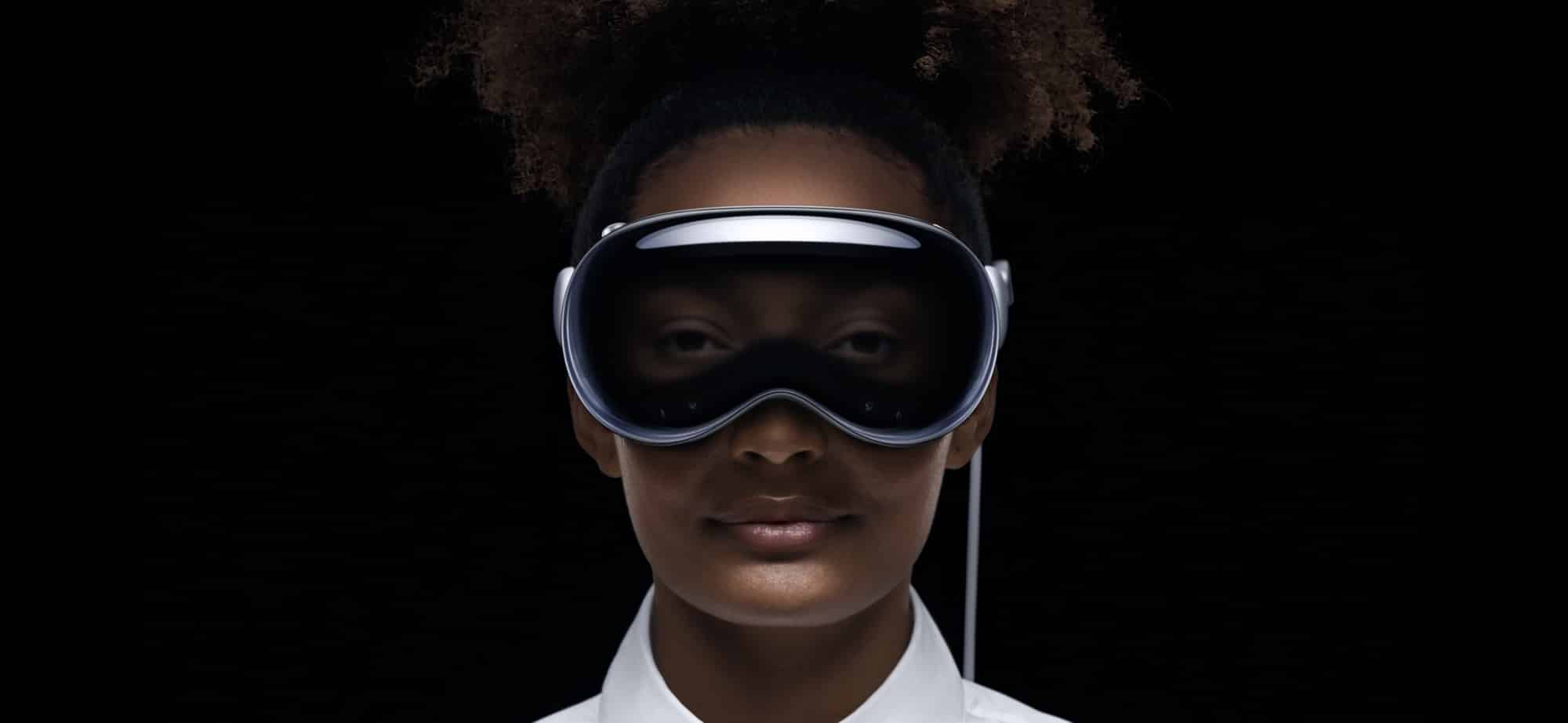 Eine Person trägt das Apple Vision Pro-Headset vor einem schwarzen Hintergrund