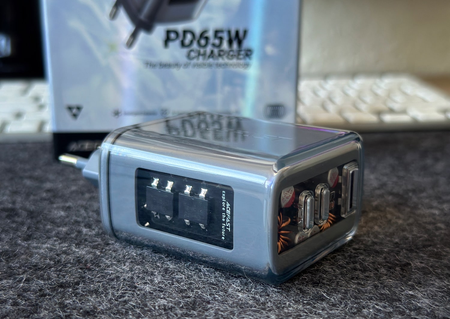 Acefast 65W Ladegerät in Grau samt Verpackung auf einem Schreibtisch