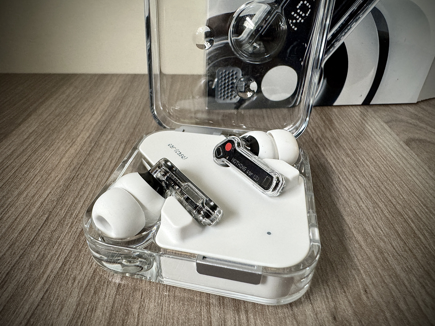 Weiße Nothing Ear 2 mit aufgeklapptem Ladecase und Verpackung im Hintergrund