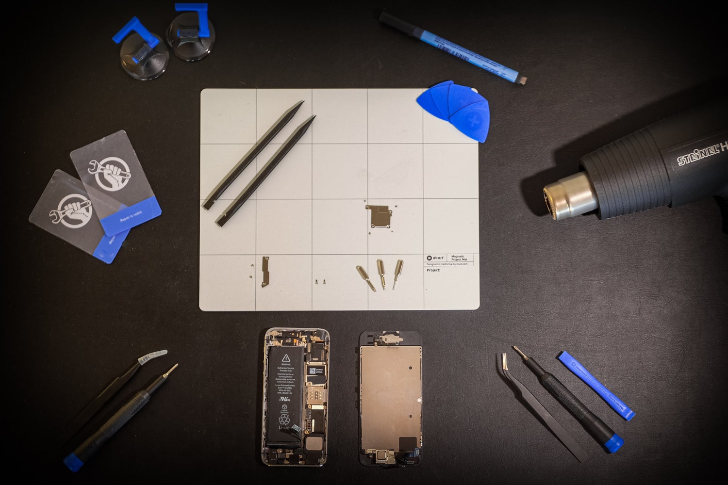 Ein Tisch ist mit Werkzeug vorbereitet für eine iPhone-Reparatur
