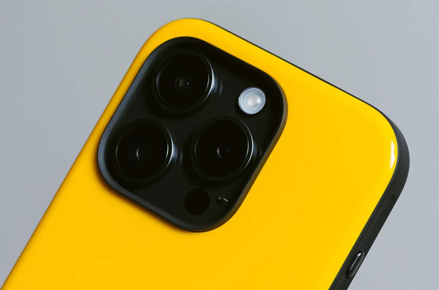 Detailaufnahme des Nomad Sport Cases in Racing Yellow vor grauem Hintergrund