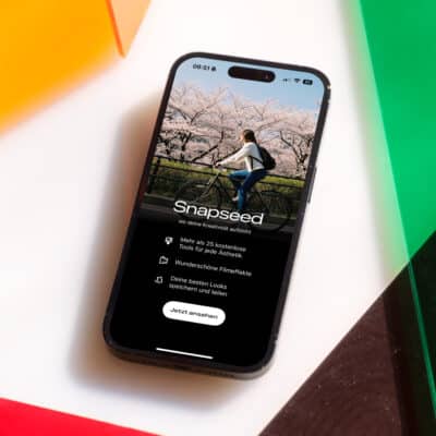 Snapseed-Startbildschirm auf einem iPhone vor buntem Hintergrund