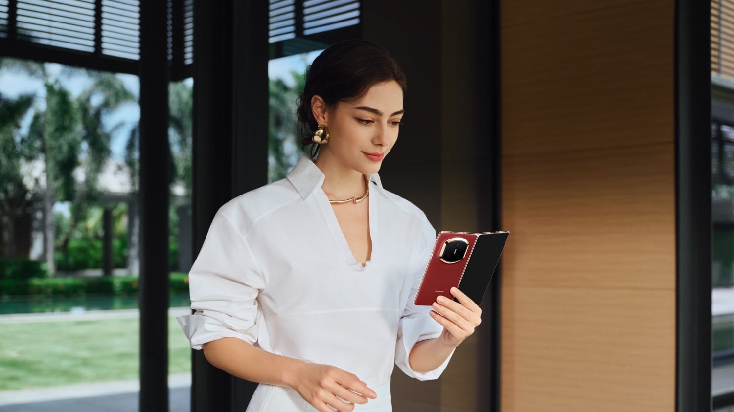 Eine Person hält ein rotes Huawei Mate X7 in den Händen und schaut auf das Display