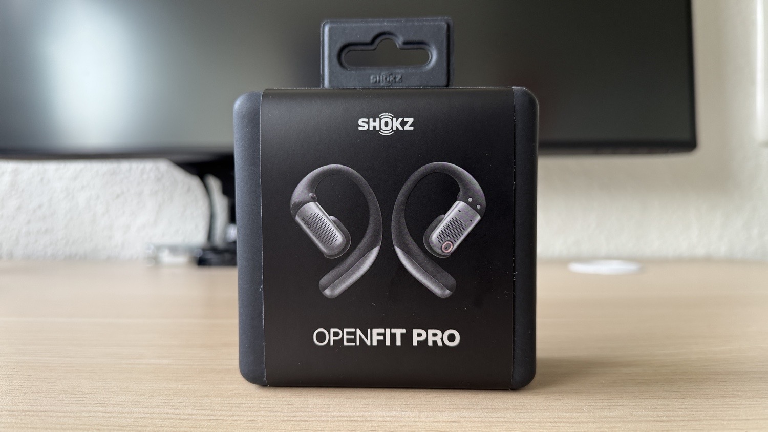 Verpackung der Shokz OpenFit Pro in Schwarz auf einem Schreibtisch