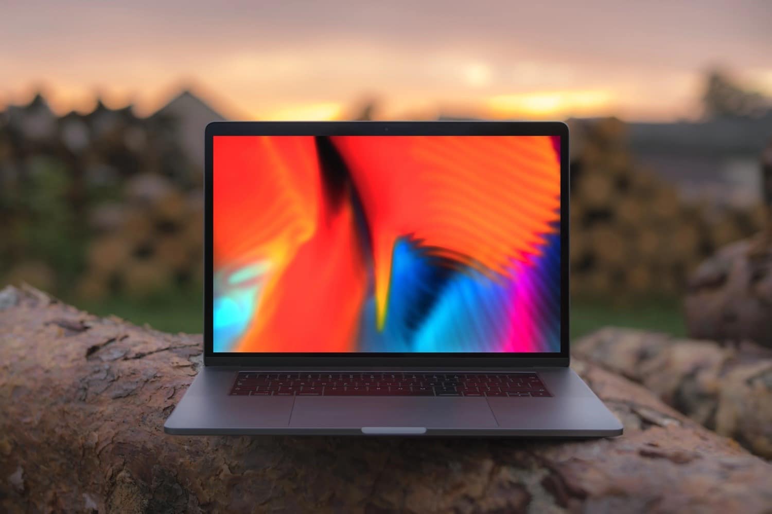 Geöffnetes MacBook liegt auf einem großen Stein