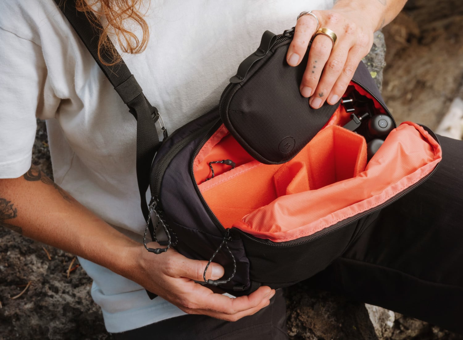 Moment Balance Sling Bag in Schwarz wird gerade befüllt