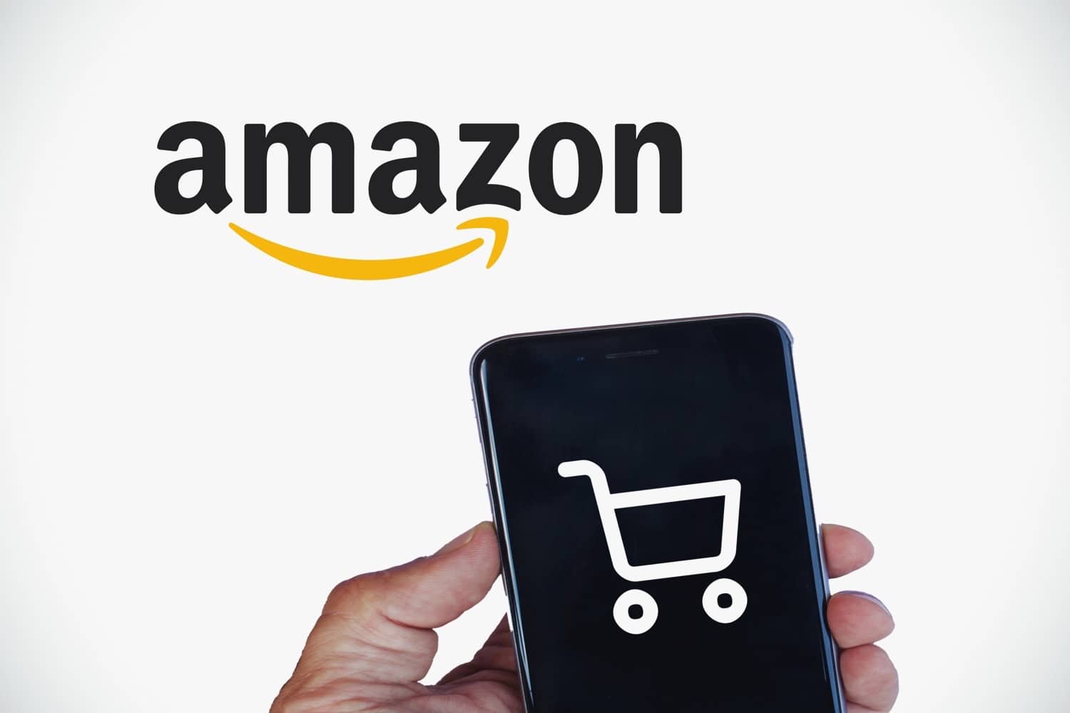 Ein Amazon-Logo im Hintergrund, vorne ein Smartphone mit einem Einkaufswagen-Symbol