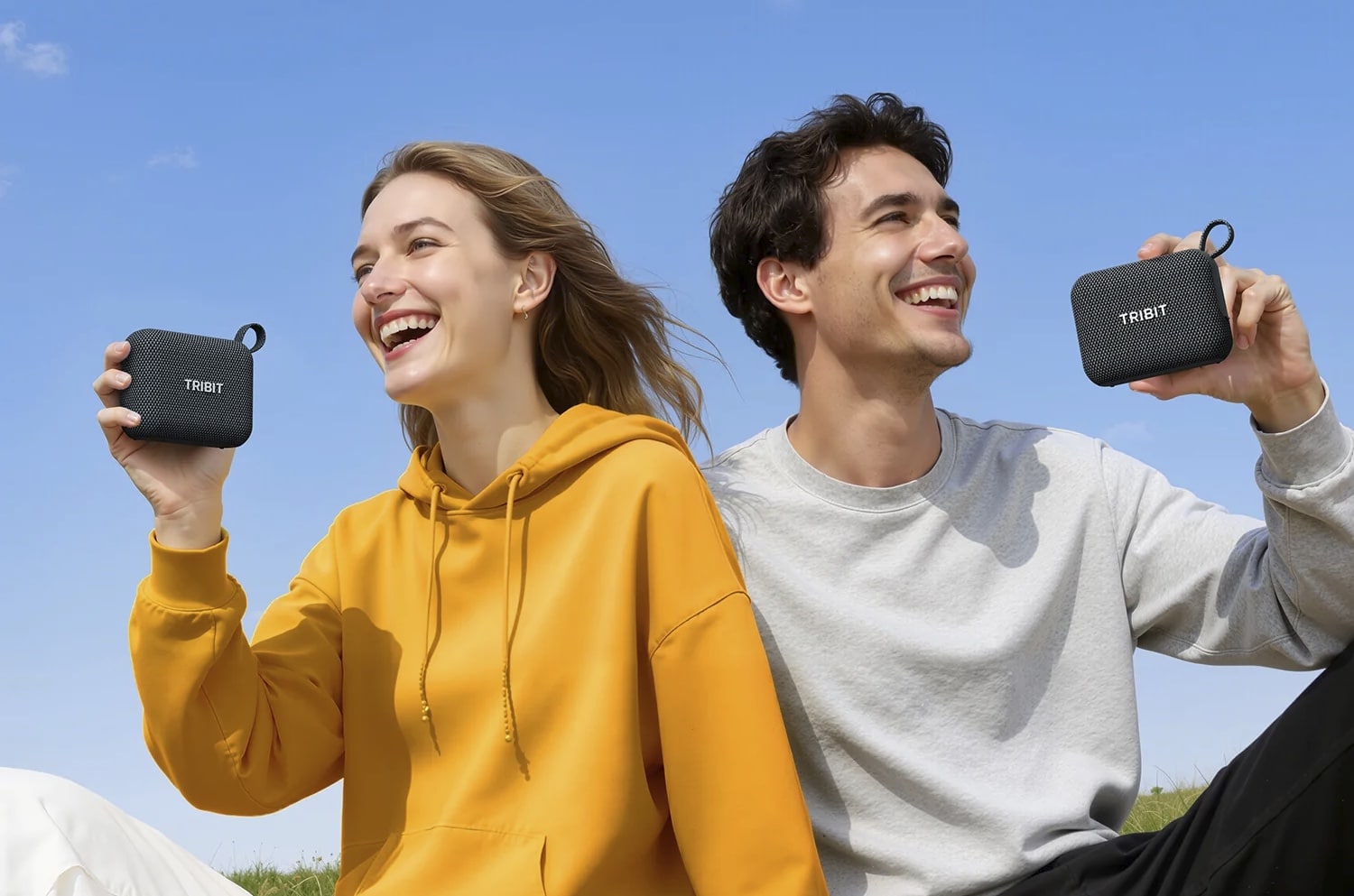 Zwei Personen halten jeweils einen Tribit PocketGo Mini lachend in die Kamera