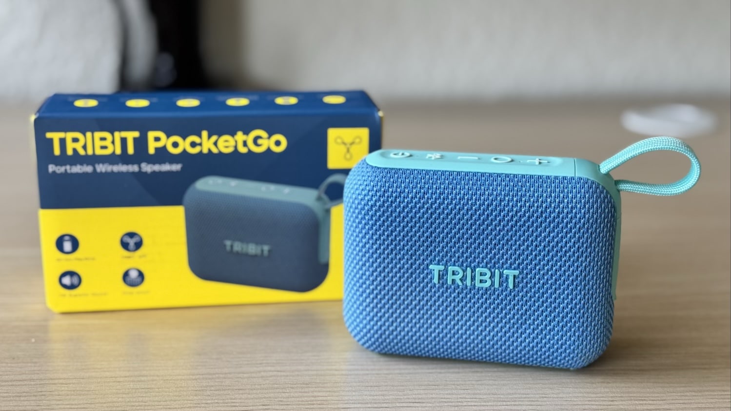 Tribit PocketGo Mini in Hellblau neben der Verpackung auf einem Tisch