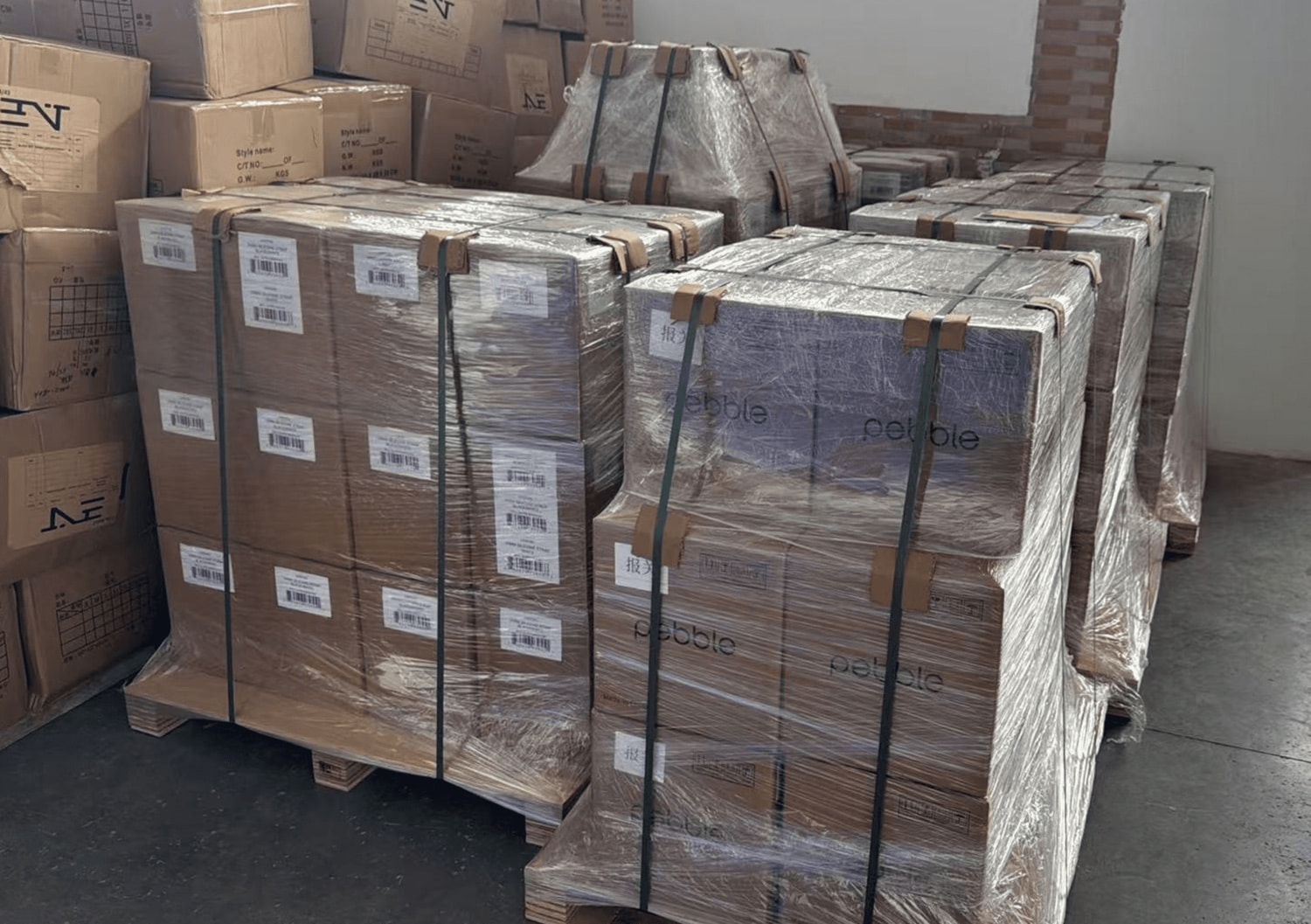 Zahlreiche Kartons auf Paletten mit Pebble Round 2-Smartwatches
